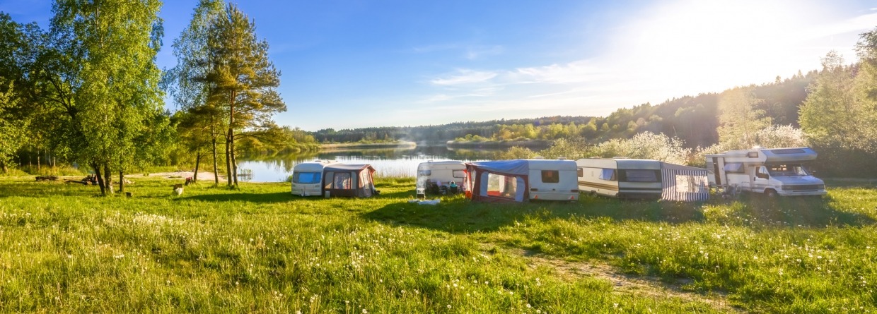 familie vakantie op een camping met caravans en campers rondom een meer