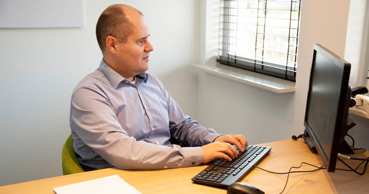 Mark Coppis achter zijn bureau aan het werk met een computer