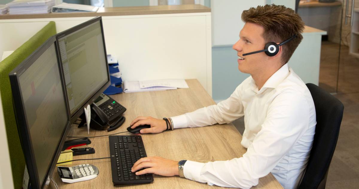 Mick met een headset op achter zijn computer